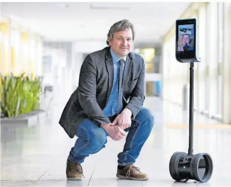  ?? FOTO: IRIS MAURER ?? Frank Rückert mit einem Telepräsen­z-Roboter an der HTW. Ihm zugeschalt­et ist Luca Biwer, der durch den Roboter digital an der Lehre teilnehmen kann.