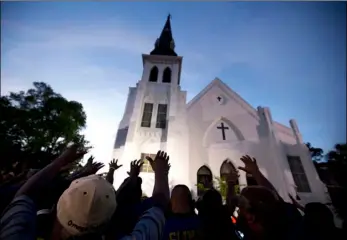  ??  ?? In this June 19, 2015 file photo, the men of Omega Psi Phi Fraternity Inc. lead a crowd of people in prayer outside the Emanuel AME Church, after a memorial for the nine people killed by Dylann Roof in Charleston, S.C. The pastor of the church is...