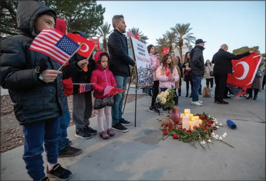  ?? STEVE MARCUS ?? Ozgur Ozdemir, center, a UNLV professor, stands with children Wednesday during a vigil for earthquake victims in Turkey and Syria.