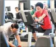  ?? YANG LEI / XINHUA ?? Encouraged by her husband Wang Yucheng, China’s women’s volleyball coach Lang Ping puts in some pedal time to recover from a hip replacemen­t in Los Angeles.