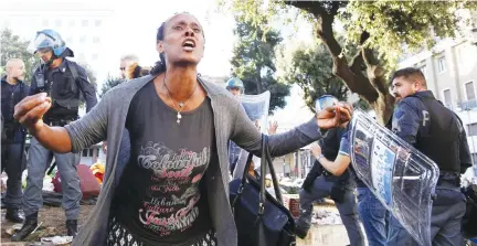  ??  ?? A refugee protests in the street after being removed on Thursday by police officers from a small square in central Rome, Italy. (Reuters)