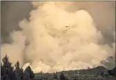  ?? NOAH BERGER — THE ASSOCIATED PRESS ?? A helicopter passes a smoke plume while battling the Lava Fire in Weed on Thursday.