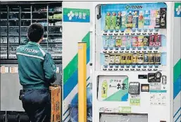  ?? TORU YAMANAKA / AFP ?? Un empleat reproveint una màquina de venda automàtica a Tokyo