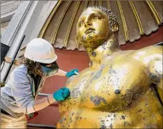  ?? Andrew Medichini / Associated Press ?? Vatican Museum restorer Alice Baltera works on restoring the bronze Hercules statue in the Round Hall of the Vatican Museums on Thursday.