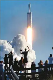  ?? JOE BURBANK/ORLANDO SENTINEL ?? The crowd cheers at Playalinda Beach in the Canaveral National Seashore, just north of the Kennedy Space Center, during the launch of the SpaceX Falcon Heavy rocket on Feb. 6, 2018.