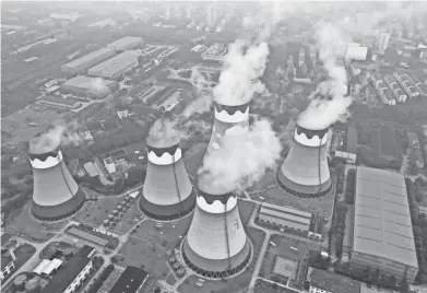  ?? CHINATOPIX VIA AP FILE ?? Steam billows out of the cooling towers at a coal-fired power station in Nanjing in east China’s Jiangsu province Sept. 27. In China, power outages have followed high prices for coal and gas.