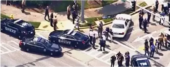 ??  ?? Deadly rampage: Police at the Capital Gazette newspaper’s HQ yesterday