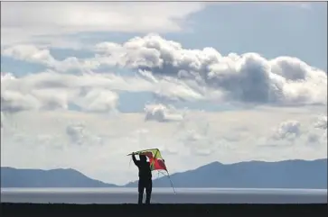  ?? Luis Sinco Los Angeles Times ?? HOBBYIST Ted Rivera prepares to fly a kite on a cloudy and breezy Friday afternoon at Angels Gate Park in San Pedro. Parts of the Southland already have experience­d complicati­ons because of recent rain.