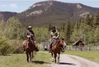  ?? (Todd Korol/Reuters) ?? RANCHERS RENIE BLADES (left) and roots musician Corb Lund ride their horses north of Blairmore, Alberta.