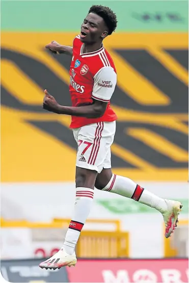  ??  ?? Bukayo Saka celebrates after opening the scoring for Arsenal at Molineux