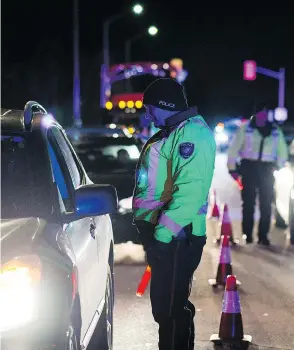  ?? JAMES PARK FOR NATIONAL POST ?? An Ottawa police officer conducts a RIDE check that screens for alcohol and cannabis on Thursday, the day after Canada legalized recreation­al marijuana use.