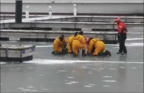  ?? ADAM DODD - THE NEWS HERALD ?? Members of the Cleveland Fire Department and the U.S. Coast Guard conducted cold water rescue training on the docks of Lake Erie, February 13.