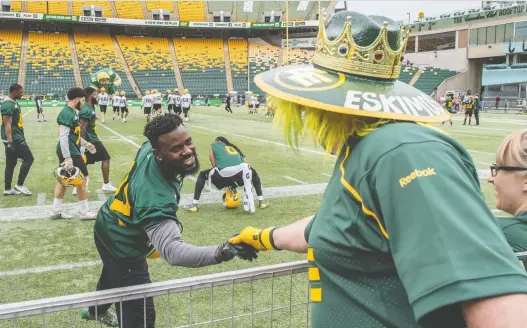  ?? SHAUGHN BUTTS ?? Linebacker Nick Taylor greets Esks super fan Scott Weech during Fan Day during an open Eskimos practice at Commonweal­th Stadium in June.