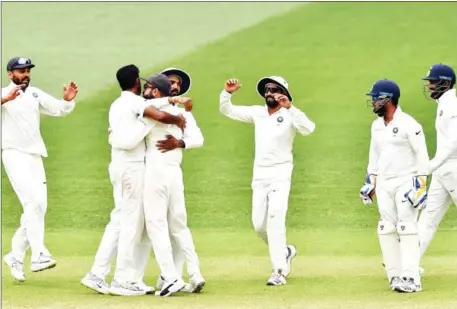  ?? PETER PARKS/AFP ?? India’s captain Virat Kohli (second left) celebrates India’s 31-run victory in the first Test of their four-match series against Australia with teammates at the Adelaide Oval on Monday.