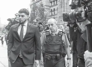  ?? Chris Young / Associated Press ?? Astros closer Roberto Osuna, left, leaves a Toronto court on Tuesday, when the former Blue Jays pitcher agreed to a peace bond that led to the withdrawal of an assault charge against him.