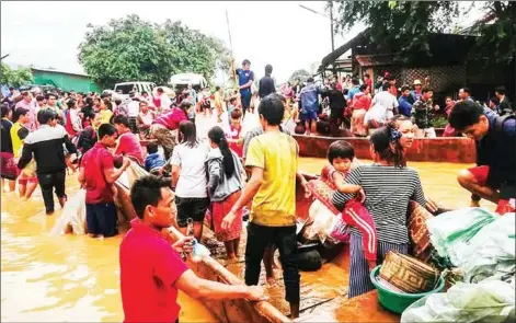  ?? HANDOUT / ATTAPEU TODAY / AFP ?? Displaced residents arrive by boat in floodwater­s in the Lao province of Attapeu after a dam collapsed on July 23. In Cambodia’s Stung Treng province people have been evacuated to higher ground as waters from the disaster raise the level of a local river.