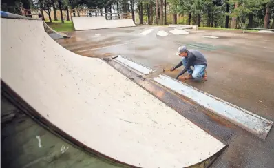  ?? MEEGAN M. REID/KITSAP SUN ?? Poulsbo Skate Park Community Coalition member Erik Payne removes the metal edging of the ramps to be reused in a rebuilt skate park after the closure of the current one at Raab Park on March 25.