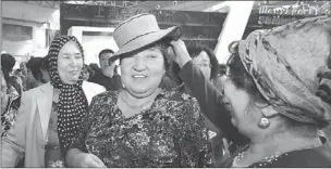  ?? ZHAO GE / XINHUA ?? A Uygur woman tries on a hat made in Kyrgyzstan at the First China-Eurasia Expo held in Urumqi, the Xinjiang Uygur autonomous region, in September 2011.