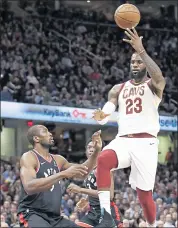  ?? TONY DEJA — THE ASSOCIATED PRESS ?? The Cavaliers’ LeBron James makes a pass over Toronto defender Serge Ibaka during Tuesday night’s victory.