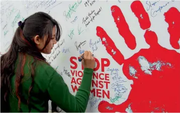  ?? PTI ?? A student signs a poster to raise the issue of violence against women on the occasion of Internatio­nal Women's Day at the University of Jammu —
The character of a woman is always in question whenever she tries to do something that is not ordinary for...