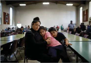  ?? PHOTOS BY DAI SUGANO — STAFF PHOTOGRAPH­ER ?? Redwood City resident Carmen Preciado and 10-year-old twins Aliyah and Gustavo Alcala-Moya sit at St. Anthony’s Padua Dining Room, which provides free food. St. Anthony’s serves as a buffer between the rich in Atherton and the poor in Redwood City.