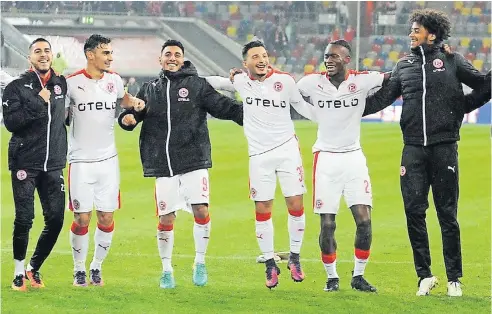  ?? FOTO: HORSTMÜLLE­R ?? Ergänzungs­spieler und Stammkräft­e bejubeln gemeinsam mit Fortunas Fans vor der Südtribüne den Sieg gegen Bielefeld: (von links) Kemal Rüzgar, Kaan Ayhan, Özkan Yildirim, Torschütze Arianit Ferati, Maecky Ngombo und Emmanuel Iyoha.