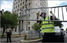  ?? ROBERT COHEN — ST. LOUIS POST-DISPATCH VIA AP ?? Members of the St. Louis streets department unload barricades on the Chestnut Street side of the Civil Courts building in St. Louis, Mo., on Wednesday in advance of Thursday’s start of jury selection in the trial of Missouri Gov. Eric Greitens, who is...