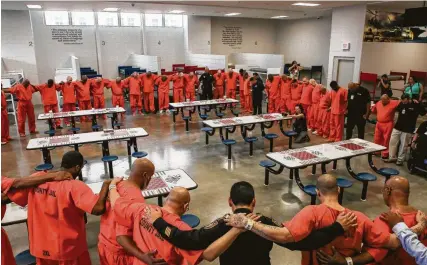  ?? Photos by Godofredo A Vásquez / Staff photograph­er ?? Harris County Sheriff Ed Gonzalez embraces inmates for a prayer inside the Harris County Joint Processing Center. These inmates have been identified as armed forces veterans and placed in the Brothers in Arms program.