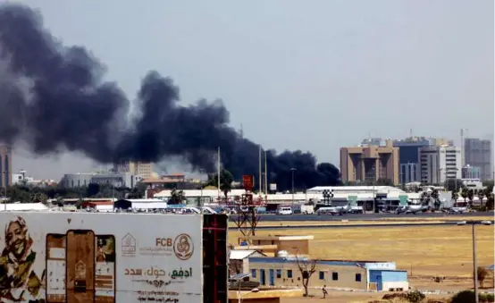  ?? AFP VIA GETTY IMAGES ?? Smoke rose above buildings around Khartoum’s airport Saturday as army and paramilita­ry forces clashed in Sudan’s capital.