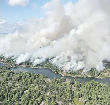  ?? DAN LEONARD / RESPONSE SPECIALIST / AFFES IGNITION / THE CANADIAN PRESS ?? An aerial view shows the extent of the Parry Sound 33 fire being fought in Ontario by firefighte­rs from across Canada, the United States and Mexico. The wildfire could force the closure of a stretch of the Trans-Canada Highway.