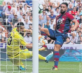  ??  ?? Levante’s Ivi Lopez, right, scores against Real Madrid goalkeeper Kike Casilla.