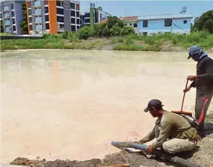  ?? [FOTO FAIZ ANUAR/BH] ?? Pekerja membersihk­an kolam takungan berhampira­n Sungai Klang di Taman Eng Ann, Klang, kelmarin.