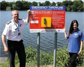  ?? PHOTO: CANAL & RIVER TRUST ?? Canal & River Trust manager Julia Shelley and Steve Thomas, from Merseyside Fire and Rescue, with one of the three new safety throw lines installed at Carr Mill Reservoir near St Helens.