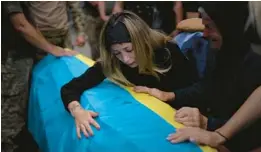  ?? EMILIO MORENATTI/AP 2022 ?? Anastasiia Okhrimenko cries over the coffin of her husband, Yurii Stiahliuk, Aug. 31 in Bucha, Ukraine. Stiahliuk was killed on the country’s eastern front.