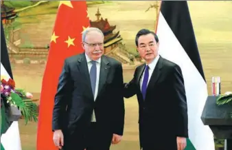  ?? WANG ZHUANGFEI/ CHINA DAILY ?? Foreign Minister Wang Yi and his Palestinia­n counterpar­t Riad al-Malki meet with reporters at the Foreign Ministry in Beijing on Thursday. Wang urged the resumption of peace talks between Palestine and Israel.