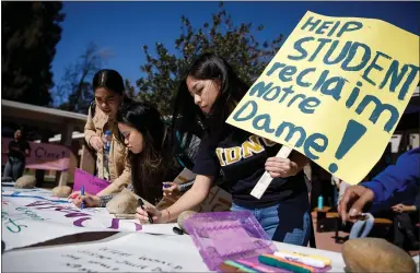  ?? DAI SUGANO — STAFF PHOTOGRAPH­ER ?? Notre Dame de Namur University students, including Natalie De La Cruz, center, write messages for posters during a protest at the Belmont school last week. Protesters say administra­tors have been ignoring the community’s pleas to keep the university open.