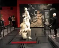  ?? LINDA DENG / CHINA DAILY ?? Visitors read introducti­on signs of the Terracotta Warriors of the First Emperor exhibit, which has 10 full-size statues.