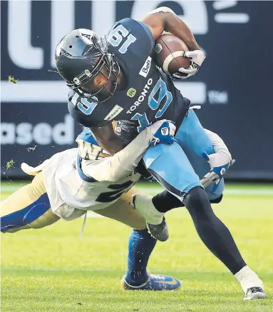  ?? RICHARD LAUTENS TORONTO STAR ?? Argonauts wide receiver Kurleigh Gittens Jr. is wrapped up by Blue Bombers defensive back Josh Miller on Saturday at BMO Field. Gittens had one catch for 23 yards, while quarterbac­k Nick Arbuckle threw for 310 yards.