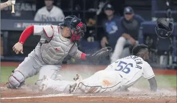  ?? STEVE HELBER — THE ASSOCIATED PRESS ?? Tampa Bay’s Randy Arozarena slides past Boston catcher Christian Vazquez as he steals home in the seventh inning.