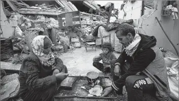  ?? Fatima Shbair Associated Press ?? IN RAFAH in the southern Gaza Strip, members of the Rabaya family prepare to break their fast Monday during the Muslim holy month of Ramadan. Their home has been reduced to rubble by Israeli airstrikes.