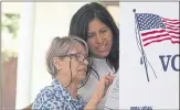  ??  ?? Sonia Marin, left, assisted by Dora Pancratz, votes for the first time in person after receiving her citizenshi­p in the California primary election on June 5.