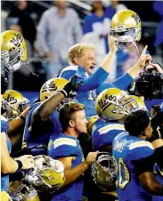  ?? Tony Gutierrez / Associated Press ?? UCLA quarterbac­k Jerry Neuheisel is carried off the field after UCLA's 20-17 win over Texas.