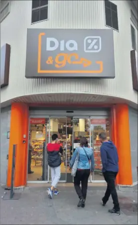  ?? / KIKE PARA ?? Tres personas entran en un supermerca­do de Dia en Madrid.