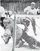  ??  ?? U.S. goalie Brandon Maxwell reaches for a puck in front of Jordan Greenway in practice.
KIICHIRO SATO/AP