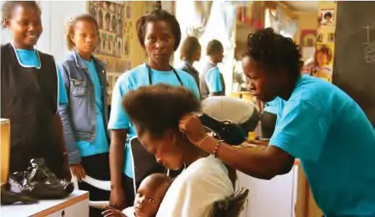  ??  ?? Young women practise to be hairdresse­rs in the Centre of Hope vocational school, Nakuru, Kenya.