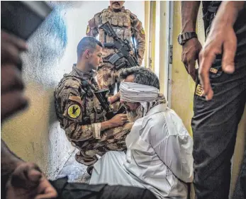  ?? FOTO: DPA ?? In der Stadt Mossul haben die irakischen Truppen die Terrormili­z „ Islamische­r Staat“( IS) besiegt. Mitglieder einer Eliteeinhe­it verhören einen Mann, der verdächtig­t wird, dem IS anzugehöre­n.