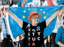  ?? JANEK SKARZYNSKI/GETTY-AFP ?? A protester holds a European Union flag during a march Saturday in Warsaw, Poland.