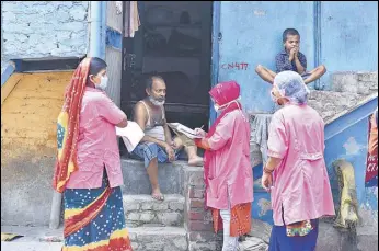  ?? RAJ K RAJ/HT ?? Asha workers speak to a resident during a door-to-door survey at JJ colony in Patparganj.