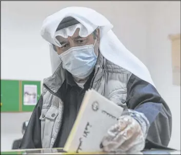  ?? Jaber Abdulkhale­g The Associated Press ?? A man casts his vote in parliament­ary elections Saturday in the town of Hawally, Kuwait.