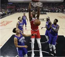  ?? AP ?? RATTLING THE RIM: Sacramento’s Harry Giles III, center, dunks on the Los Angeles Clippers Saturday.